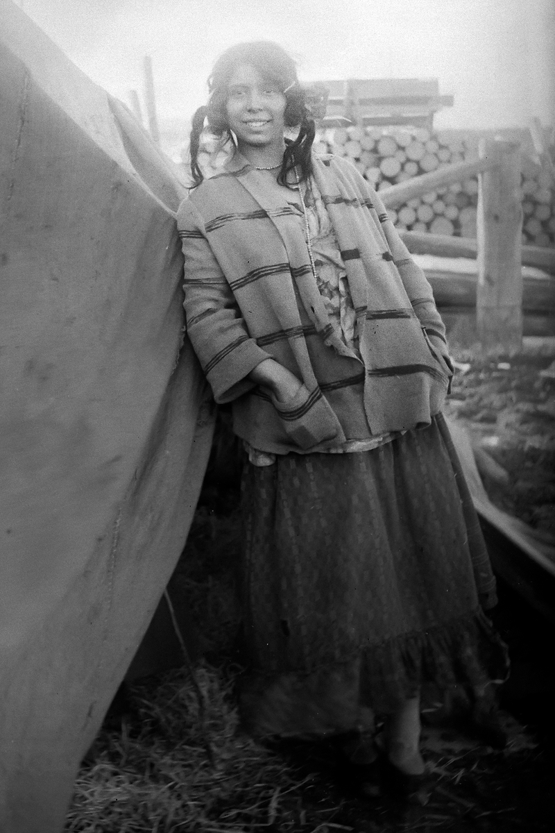 En ung kvinna poserar för kameran framför sitt bostadstält. BIlden ska enligt uppgift vara tagen i Mockfjärd i mars 1929.