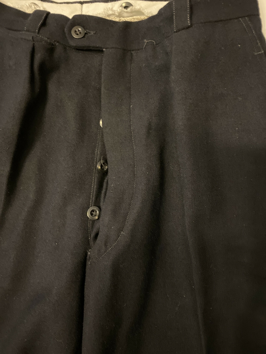 Uniformsbukse, del av NSB-uniform. Knappegylf, klokkelomme, sidelommer og baklommer med knapp.