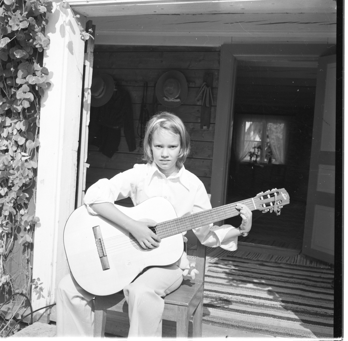 En flicka sitter med en gitarr i händerna.