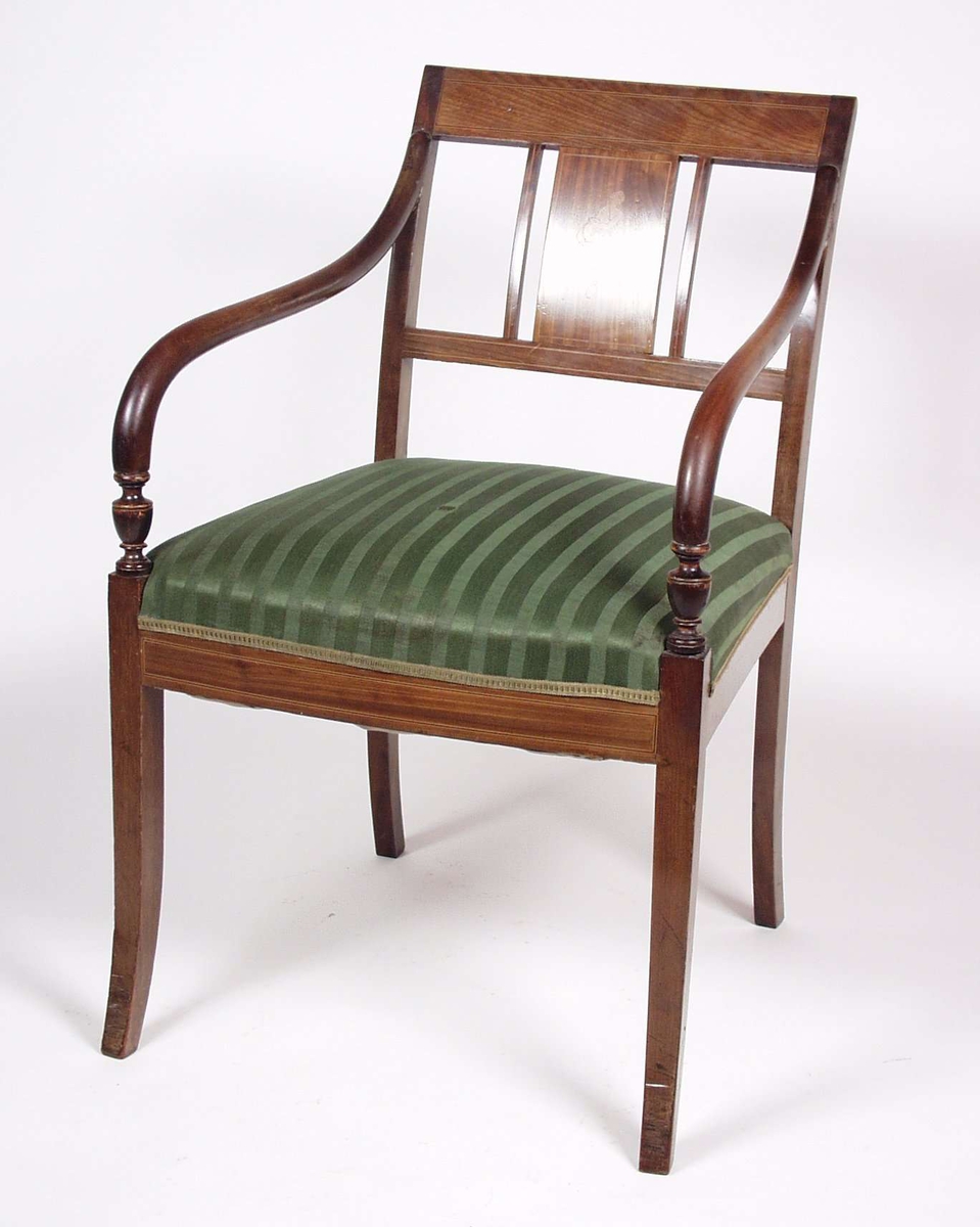 Stolen er av tre med intarsia i rygg.Stolen har stoppet sete i grønt ulltrekk, armlenene er av nøttetre.
