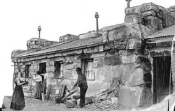 "Tong"  steinbygning med tre personer utenfor