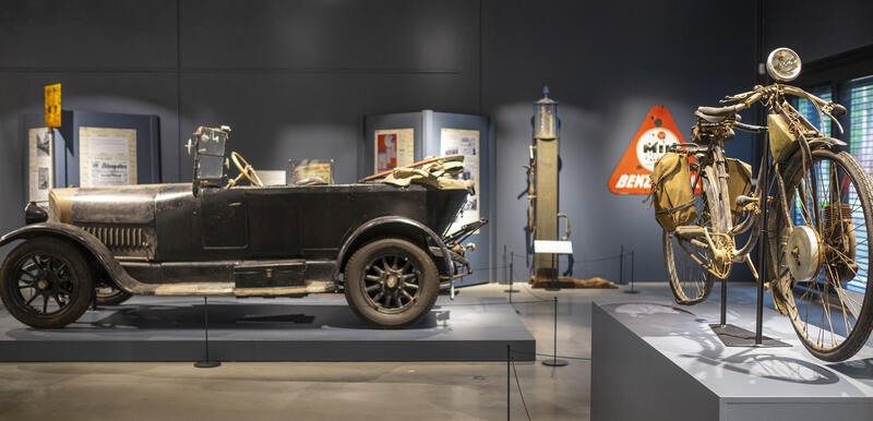 Fra utstillingen "Med skinnfrakk og lærstøvler" på Norsk kjøretøyhistorisk museum, med en eldre bil og en eldre motorsykkel.