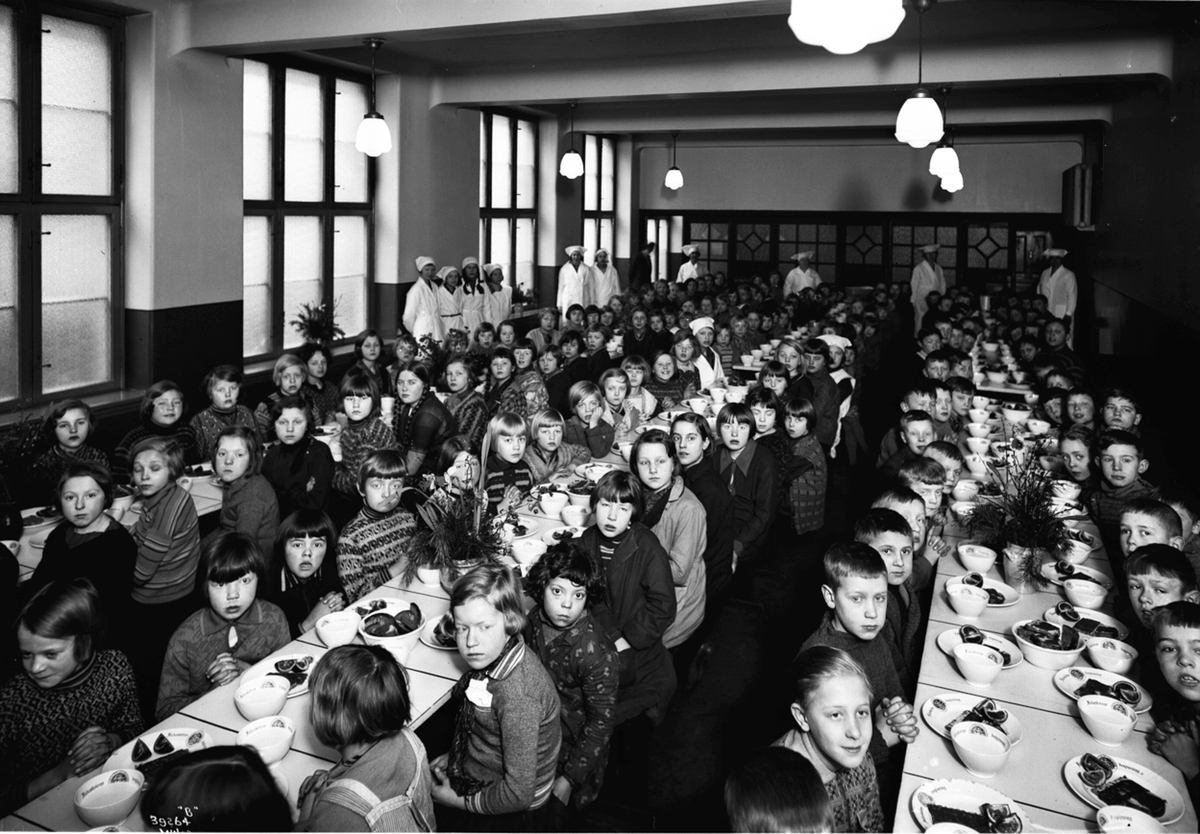 Skolefrokost på Herslebs skole i Oslo.  Alle elevene samlet i skolens kantine.  Kjøkkenpersonale sørger for ro og orden i tillegg til sunn og næringsrik mat.