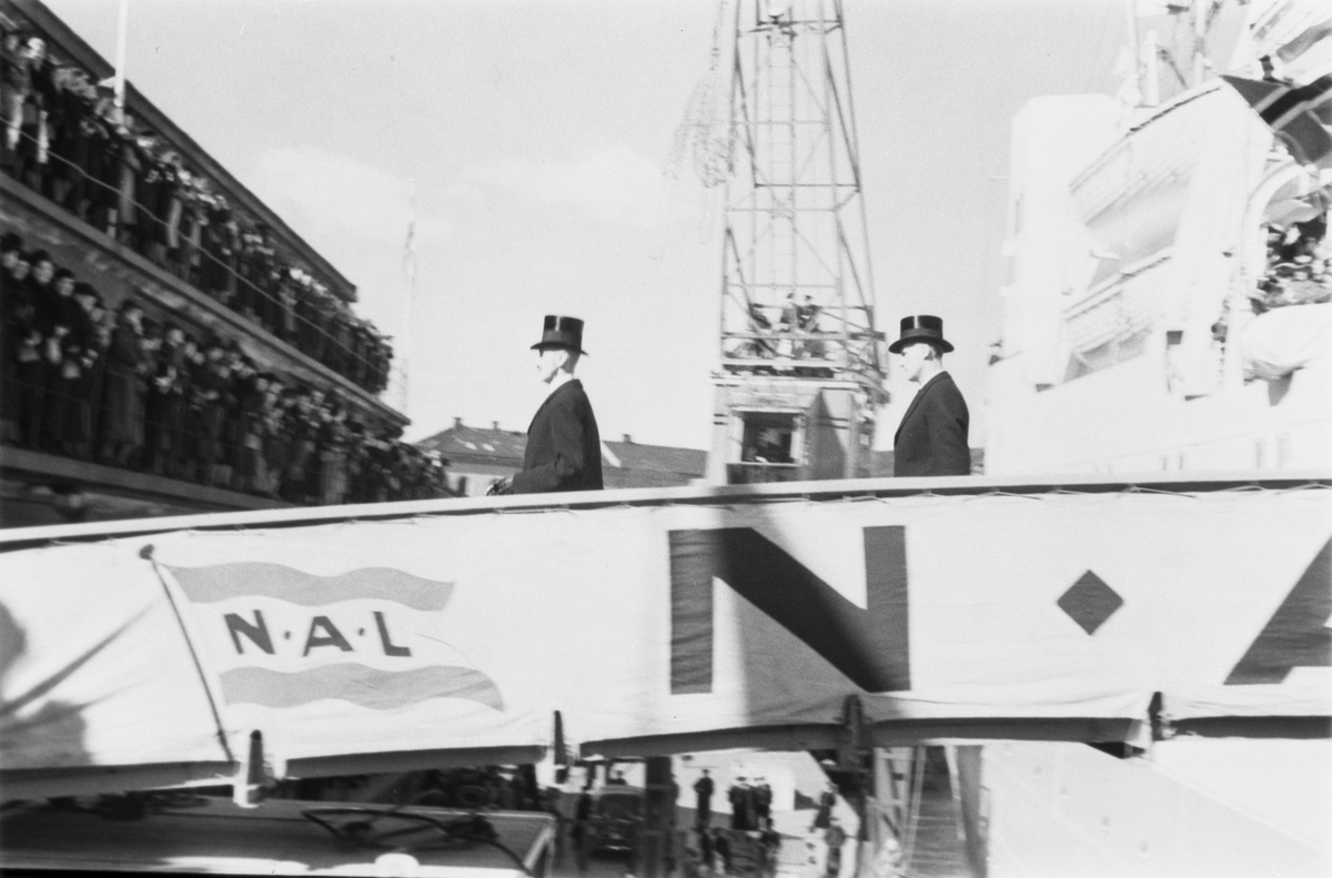 Kongen og Kronprinsen  avbildet på fra skipet til kai.  Stort oppmøte på kaien, slik tradisjonen var når "amerikabåten" ankom.