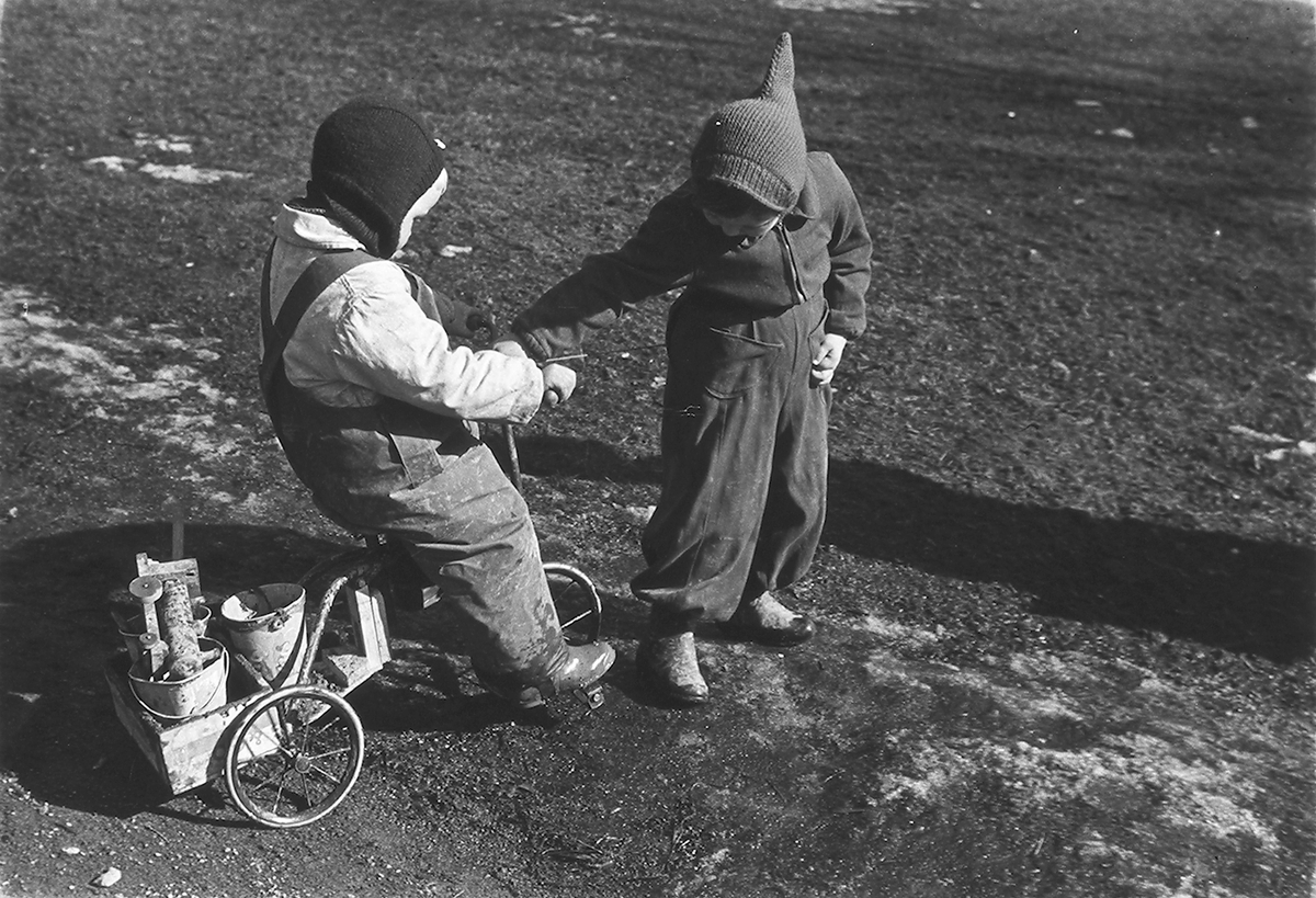 To barn med trehjulsykkel  på lekeplass. Fotografert 1940.