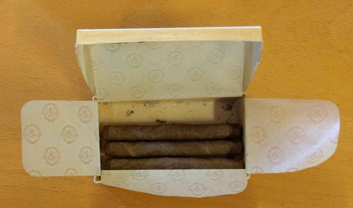 Pepitas Mild aromatisk cig.cig. Svenska Tobaksmonopolet tillverkades mellan 1951-1982. Nr 201, 10 st. Baksidan: 1 st 19 öre, 10 st 1:90 kr. Silkespapper inuti. Tre cigariller kvar i asken. Plac: M2DB.