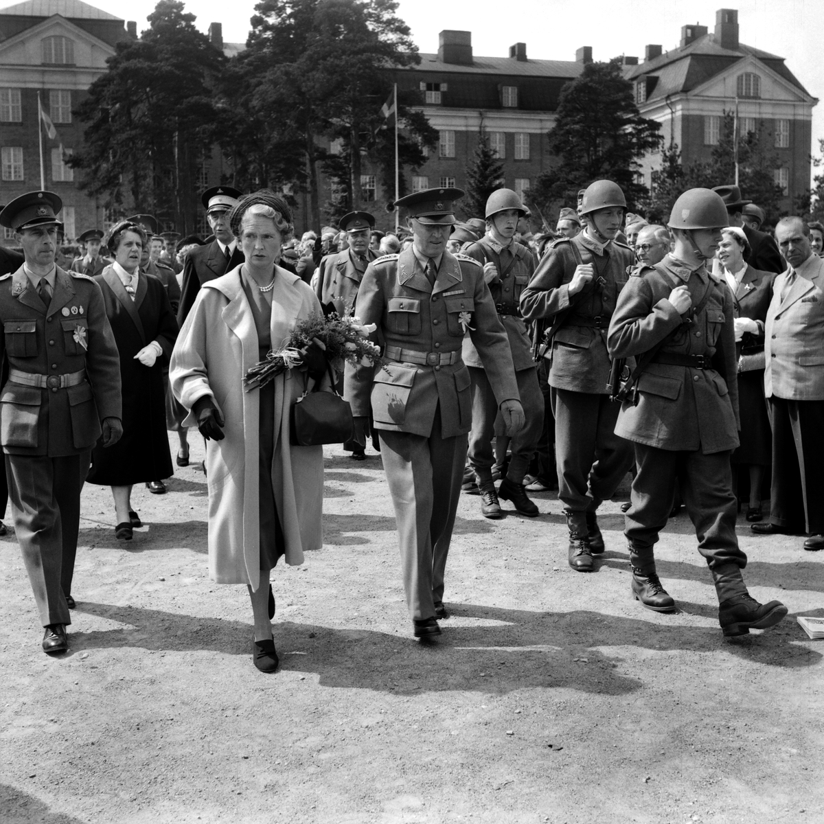 Prinsessan Sibylla med militära dignitärer och beväringar passera över kaserngården till T 1 i Linköping. Hennes besök var föranlett av 1953 års försvarsutställning som var förlagd till staden.
