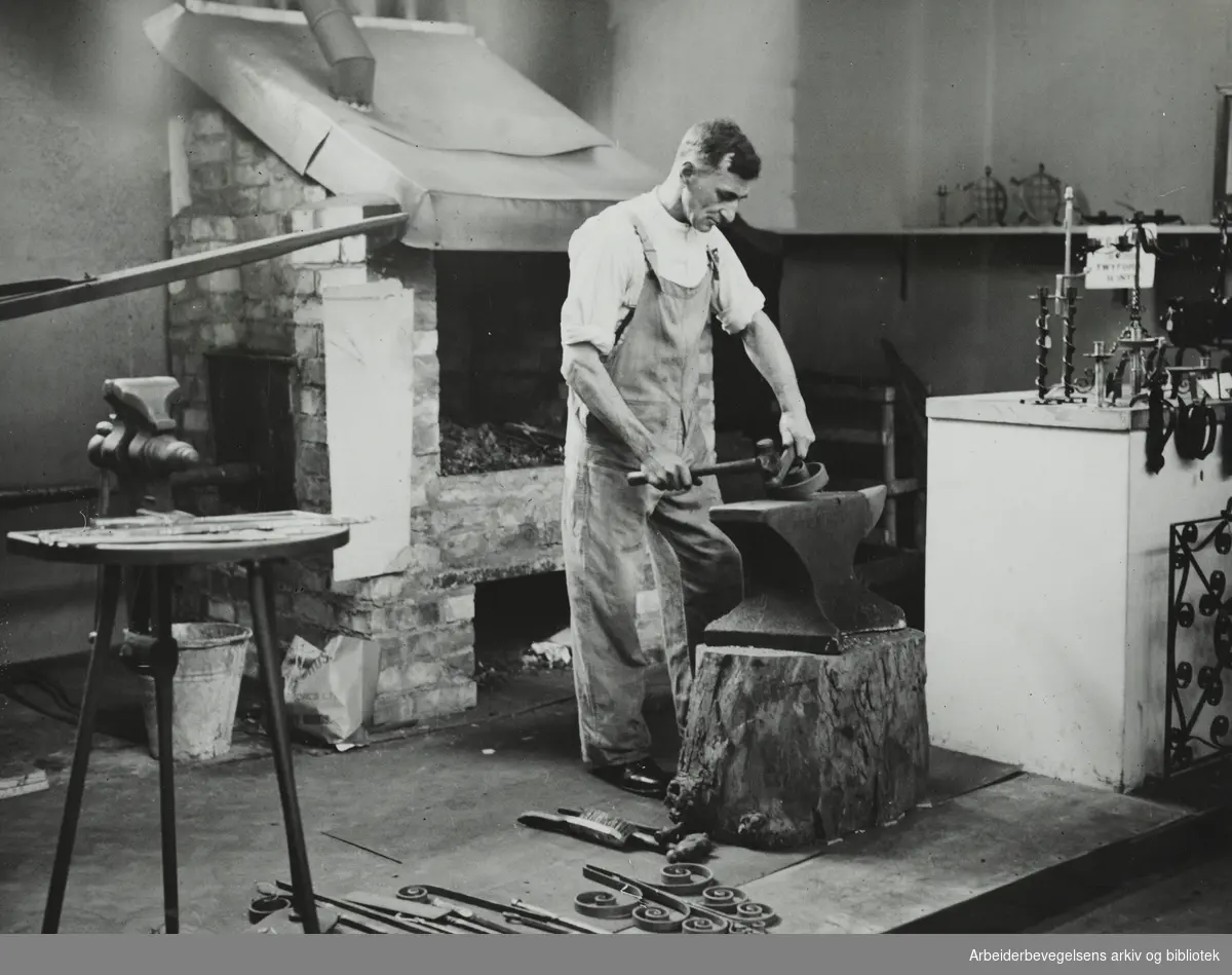Arbeidslivsreportasje fra jern- og metallfag i England. "På en utstilling i London var bygget op små verksteder fra forskjellige håndverk. Billedet viser en kunstsmed i arbeide". Arbeidermagasinet. Udatert