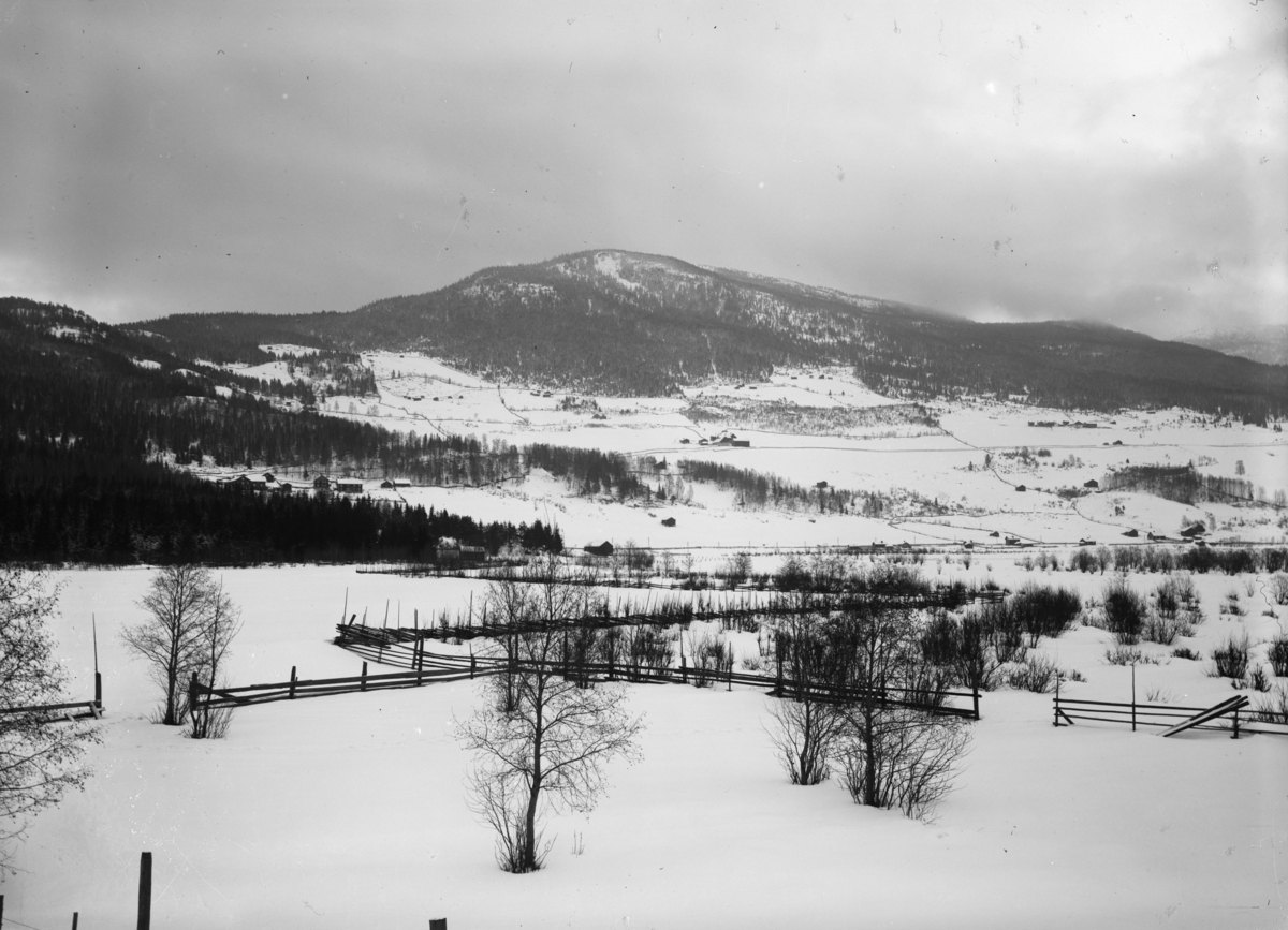 Vinterbilde med utsikt mot Hånnåkampen og Oppsalåsen, sør for Fåvang sentrum, og muligens gårdene Rørvik og Lunde.