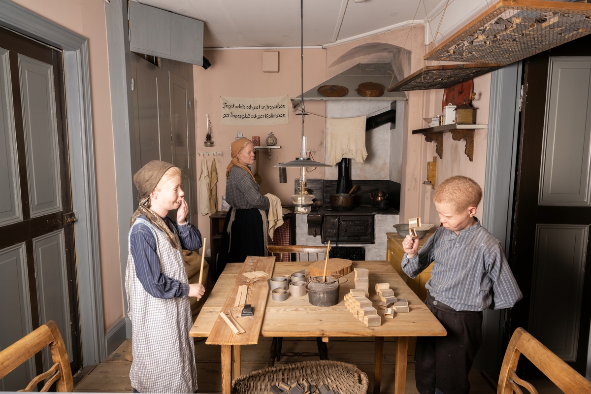 Tändsticksarbetarbostaden. Utställningen består av en miljöinteriör med kök och rum för en tändsticksarbetarfamilj i Jönköping omkring 1900. I miljön är dockor placerade med tidsenliga kläder. I köket utför två av familjens äldre barn hemarbete åt Jönköpings Tändsticksfabrik i form av tillverkning av tändsticksaskar. I taket hänger nätramar där de nyklistrade askarna ligger på tork. I fonden sysslar modern med torkning av disken.

Tändsticksarbetarbostaden är uppbyggd utifrån en verklig arbetarbostad från en fastighet i Jönköping, som tillhörde Svenska Tändsticksaktiebolaget (STAB). Jönköpings läns museum fick möjlighet att förvärva en lägenhet när byggnaden skulle rivas 1971. Köksskåp, fönster, dörrar, golv, järnspis och järnvask med rör nedmonterades i bostaden, och överfördes till länsmuseet. Museilektor Eva Londos producerade basutställningen. Tändsticksarbetarbostaden visades på länsmuseet under åren 1971-1990. År 1994 överfördes den till Tändsticksmuseet i Jönköping. De ursprungliga dockorna var skyltdockor från butiker. Tändsticksmuseet ersatte dem omkring 2009 med dockor tillverkade av dockmakare Oscar Nilsson.