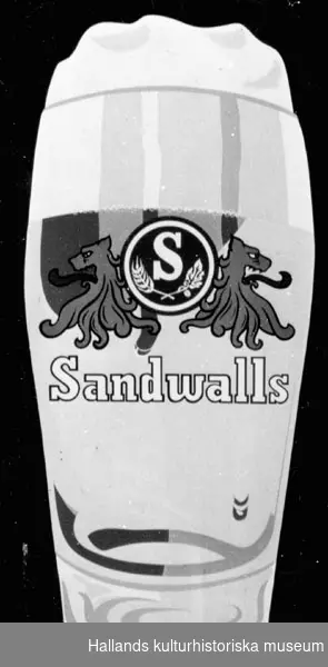 Reklamskylt av plåt med skummande ölglas i gult. Märkt: "Sandwalls", Bryggeri, Borås. Bredd: 63 cm.Höjd: 85 cm.