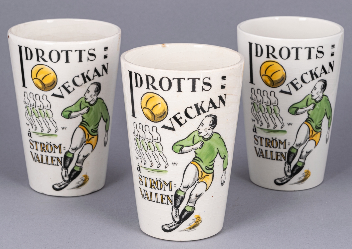 Bägare, 3 st, flintgods. Glaserad. Vit med idrottsmotiv i svart, grönt och gult. Text: "IDROTTSVECKAN Å STRÖMVALLEN 5-12 SEPT. 1926".