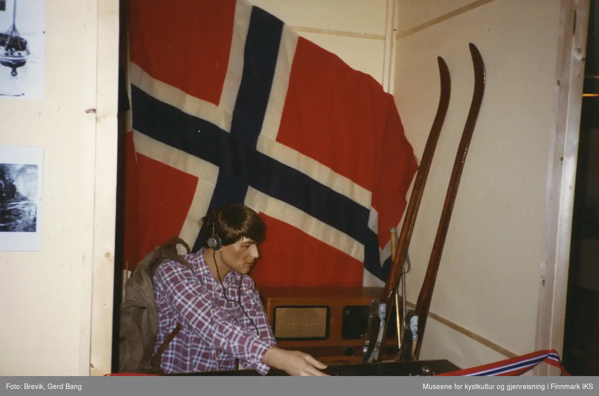 Bildet viser en del av Frigjøringsutstillingen i bystyresalen i Hammerfest som ble vist frem fra 6. juni til 10. august i 1995.
I utstillingen var det iscenesatt noen mindre rom med gjenstander og utstillingsdukker, slik denne som fremstiller et medlem av en motstandsgruppe.