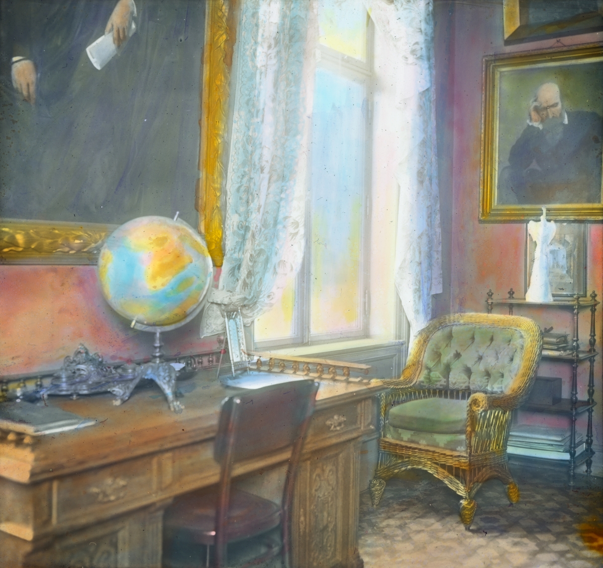 Håndkolorert dias. Dramatikeren Henrik Ibsens arbeidsværelse i leiligheten i Arbins gate. På skrivebordet står en globus sammen med et par bøker. På veggene henger portrettmalerier.