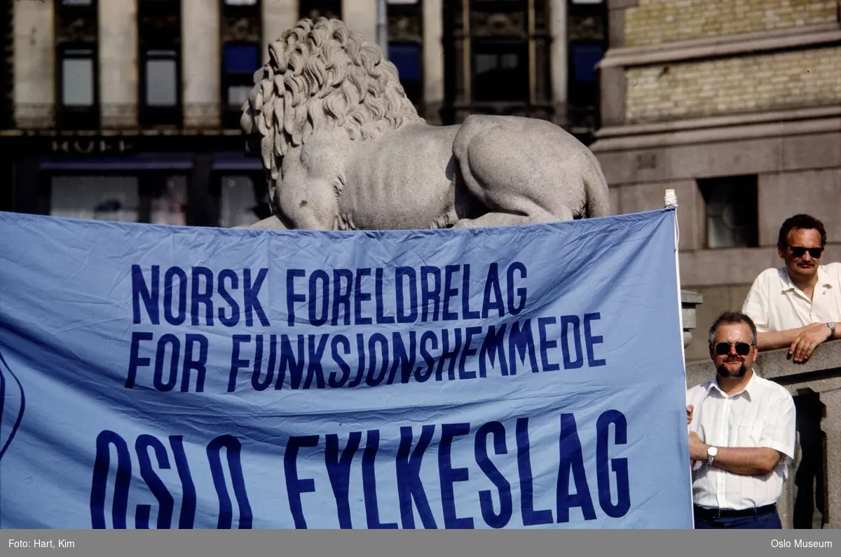 semonstrasjon, banner: "Norsk foreldrelag for funksjonshemmede. Oslo fylkeslag", menn, løveskulptur