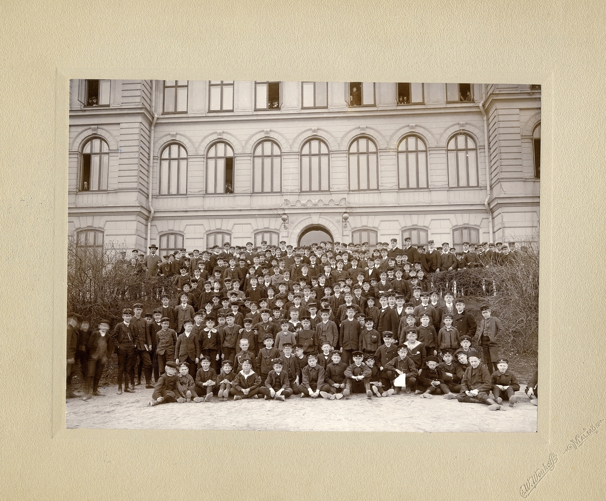 Växjö högre allmänna läroverk 1907. Rektor Josephson syns överst till vänster.
Flera olika klasser har samlats på stora trappan för gruppfoto. En del nyfikna elever skymtar i fönstren bakom.