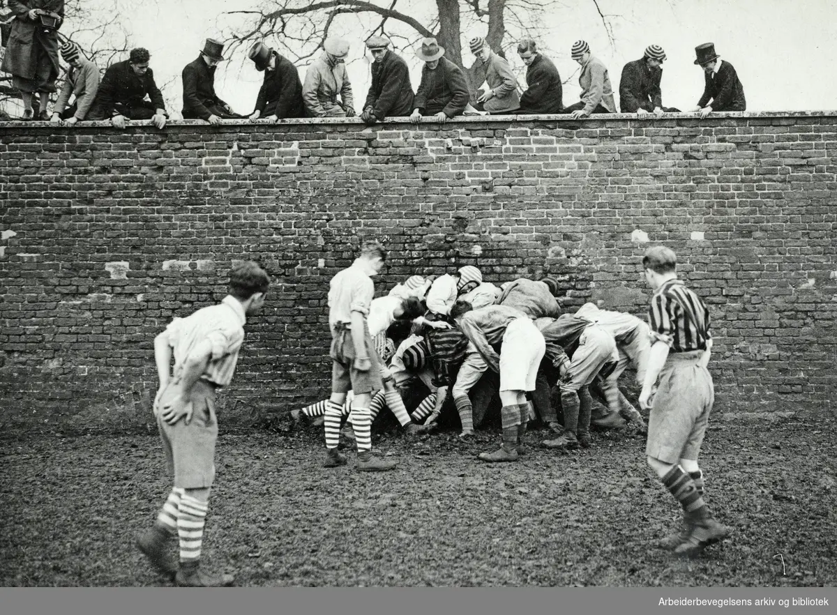 "The Eton wall game". Engelsk ballspill. På St Andrew's Day (30 november) spiller "Collegers" mot "Oppidans" til et rugby-lignende spill. Arbeidermagasinet/Magasinet for Alle. Udatert.