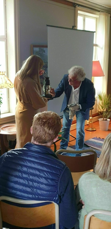 Stig Fossum tenner en avlegger av Olavsflammen på Steigen prestegård. Foto: OVF