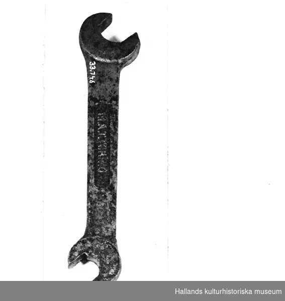 Skruvnyckel av u-typ, dubbelnyckel, av stål. Märkt: FIAT TORINO. 
Längd 22,5 cm. Bredd 4 cm. Tjocklek 2 cm.