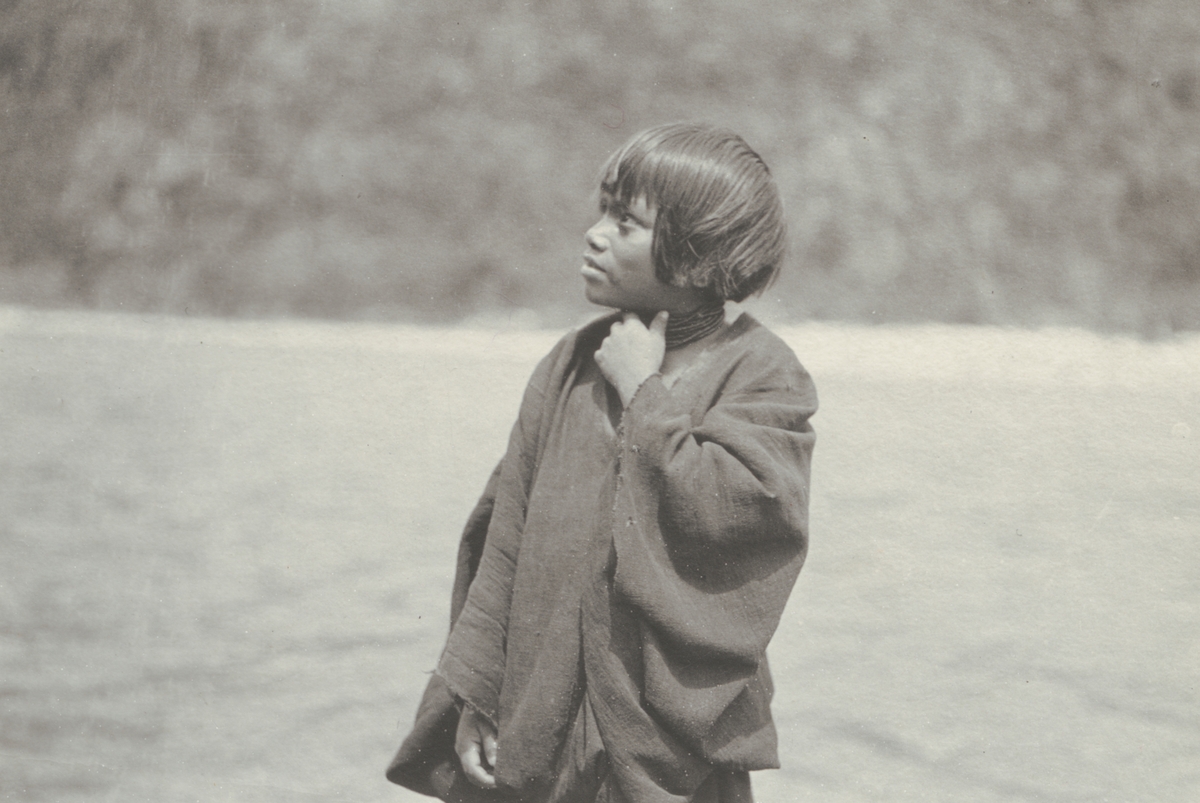 Fotografi från kuvert märkt med "Ernst Nordenskjöld". Motiv av pojke vid flod.