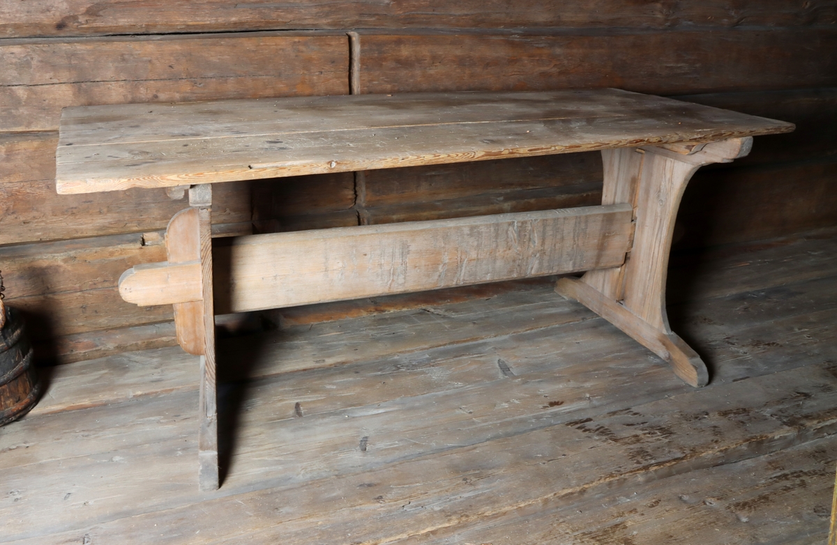 Bord tillverkad i furu, med rektangulär bordskiva. Skivan vilar på två breda ben, sammanhållna i mitten av en stabiliserande slå.
Bordet har en skuren märkning "I.N.T. 1790" på tvärslån mellan bordets ben.