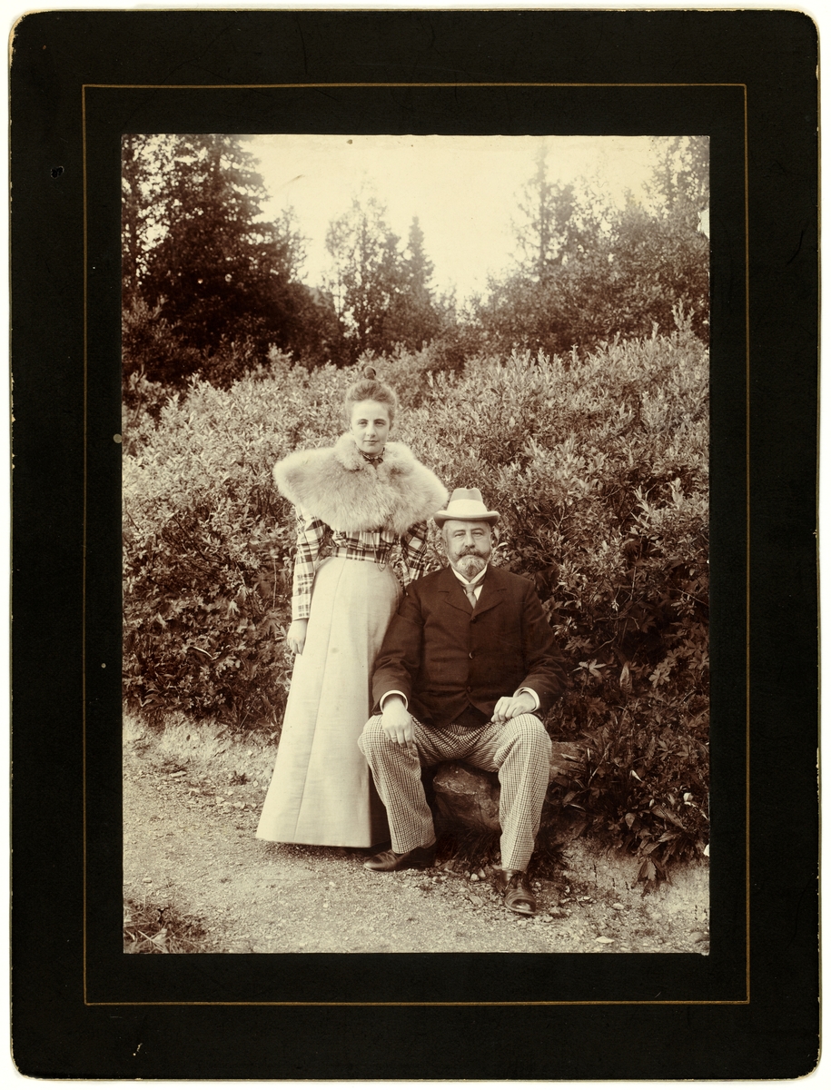 En ung kvinne står ved siden av en sittende herre i en park.
Nini Egeberg (f.Wedel Jarlsberg) står ved siden av sin far Herman Wedel Jarlsberg. I følge Ninis memoarer hadde de et nært og godt forhold.