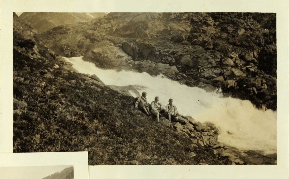Tre kvinnelig fjellvandrere sitter ved en fossende elv (Utla?) på vei fra Leirvassbu til Skogadalsbøen i Jotunheimen. De to til høyre er antagelig Lucy og Mimi Egeberg. Fotografert juli 1926.