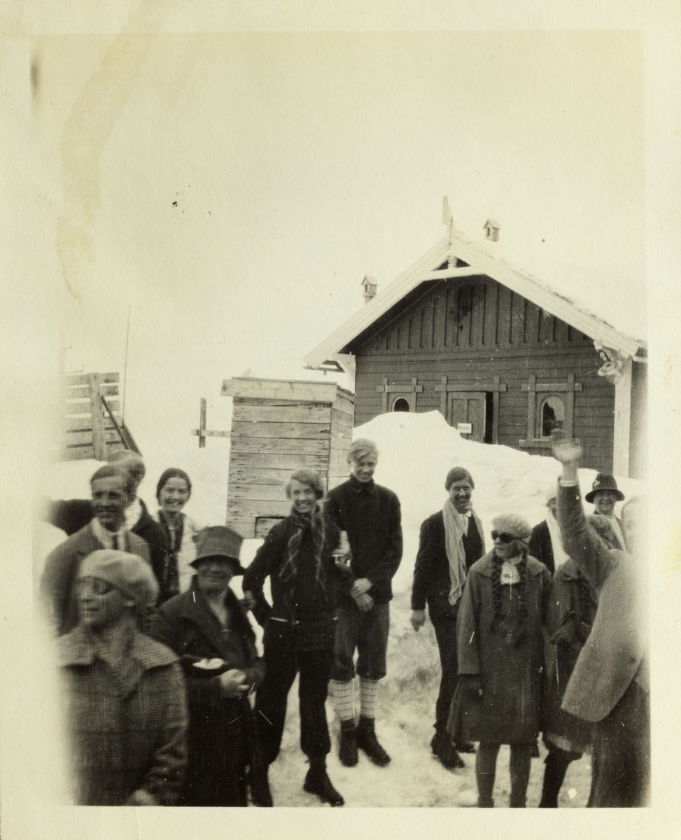 Sonja Henie omringet av tilskuere ved avreise fra Finse. Lucy Egeberg bak til venstre. Fotografert påsken 1928.