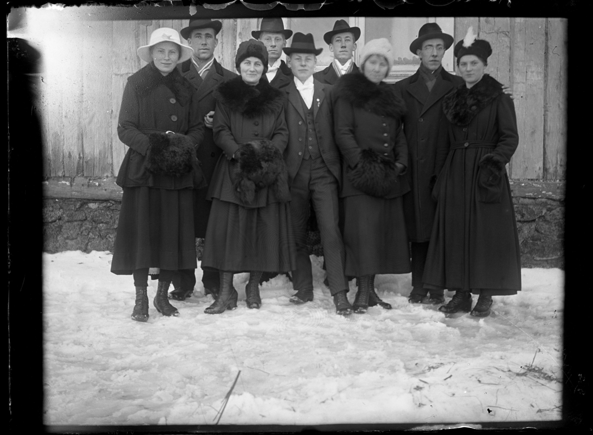 Porträtt av nio personer, män och kvinnor i vinterkläder.