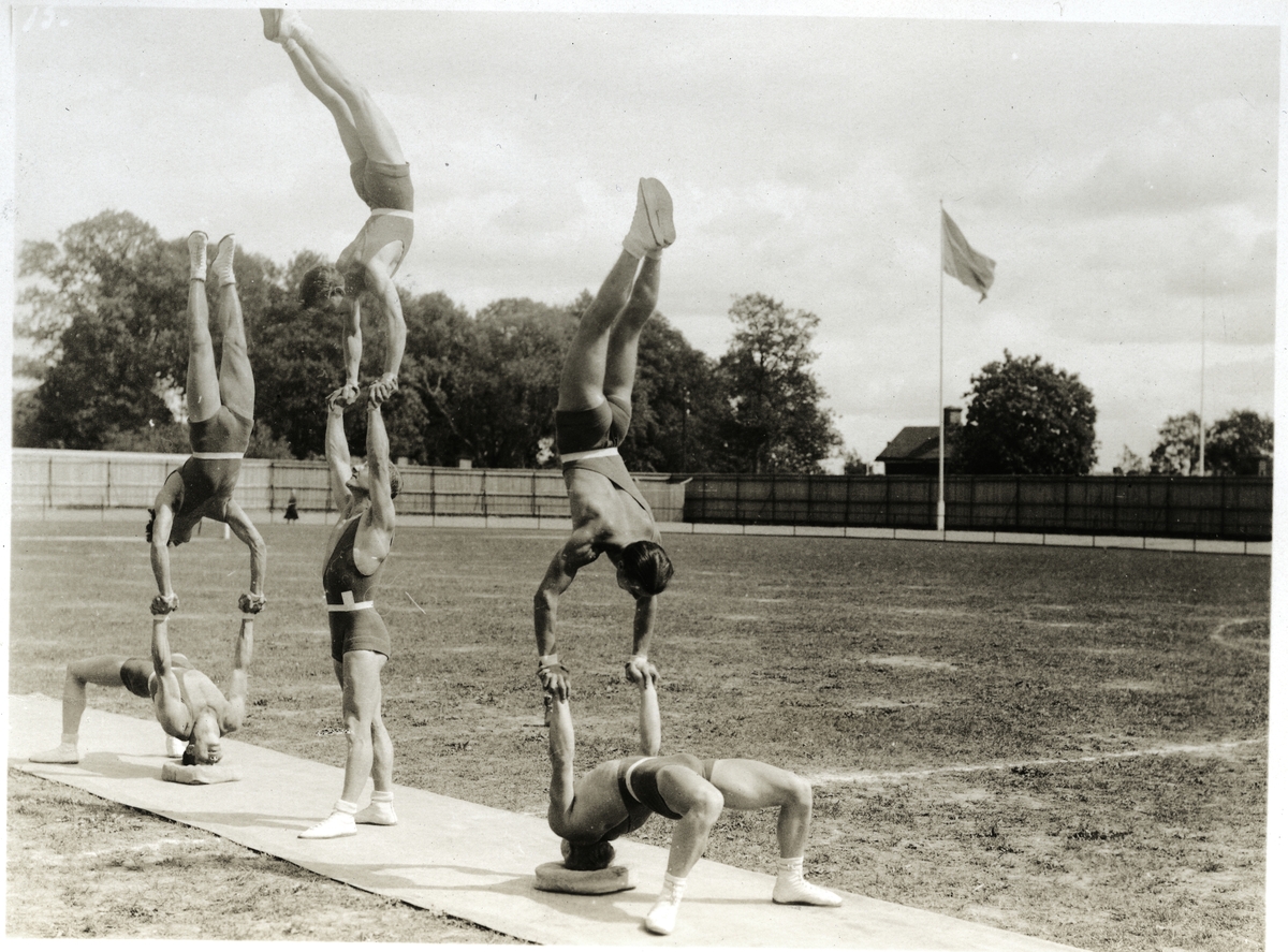 Västerås. 
En grupp gymnaster utför övningar på Idrottsplatsen bred vid Herrgärdsskolan. 1940-tal.