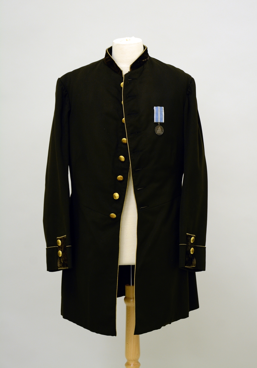 A.Uniformsjakke. Uniformsfrakk fraa Skiens borgarkorps. Frakken er av svart klæde med smal staakrage av violett fløyel, gult "midtsøyme" (kanting) etter krage og framkant, etter flakkene paa ermar og bakstigler.Skoren i bonjour, med ei knapperad paa 8 knappar framme, 3 knappar paa flæyelsklæddde flakka, paa kvar erm og 3 paa kvar av dei tvo lumeflakkene paa bakstiglet. Alle knappar er skaalforma. Hornknappar paa innsida. Fôret er vattert king ermestaupi. Fra protokoll.
B. Medalje, svensk medalje fra 1886 i blått og hvitt ripsbånd.