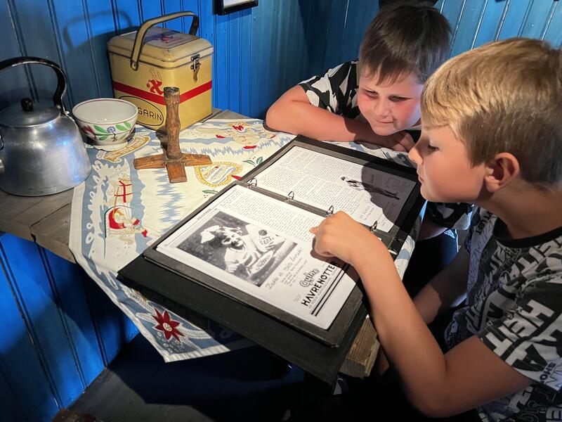 Two young children reading in an album.