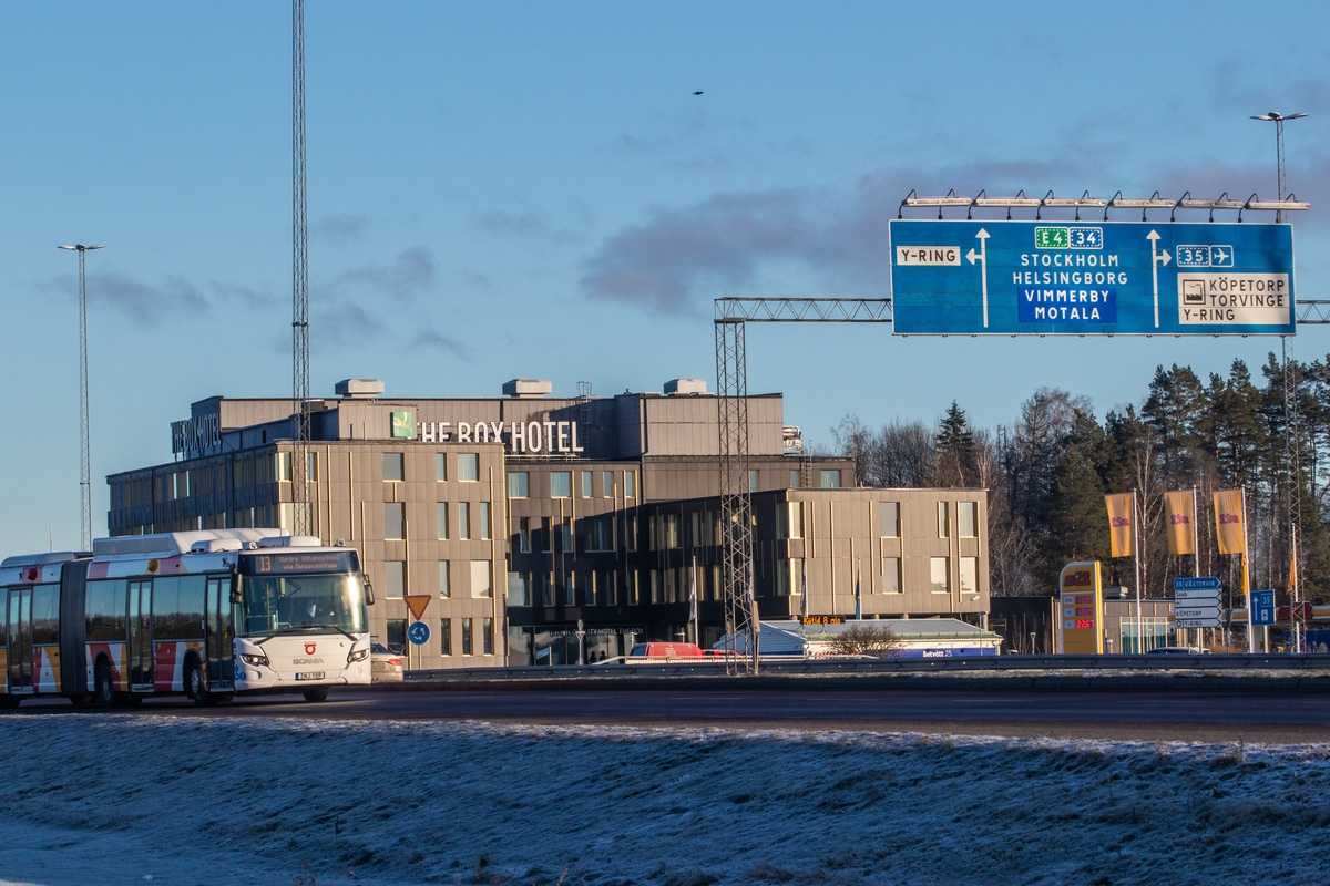 Vy mot Kallerstadrondellen med The Box hotell. The Box hotell byggdes år 2018. Man ser en buss från Östgötatrafiken i förgrunden. Rondell. Vägskylt. Buss.
