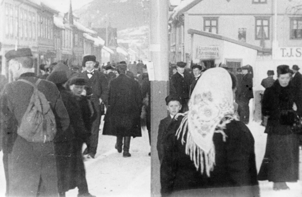 Stillbilde fra Albert Hougners film fra Storgata, Lillehammer 1912. Menneskemengde på Lilletorget. Til høyre forretningen til TJ Strand i Storgata 87