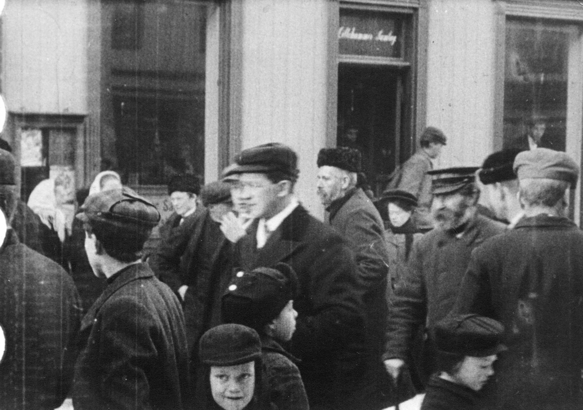 Stillbilde fra Albert Hougners film fra Storgata, Lillehammer 1912.  En gruppe mennesker utenfor Lillehammer Samlag, Storgata 68