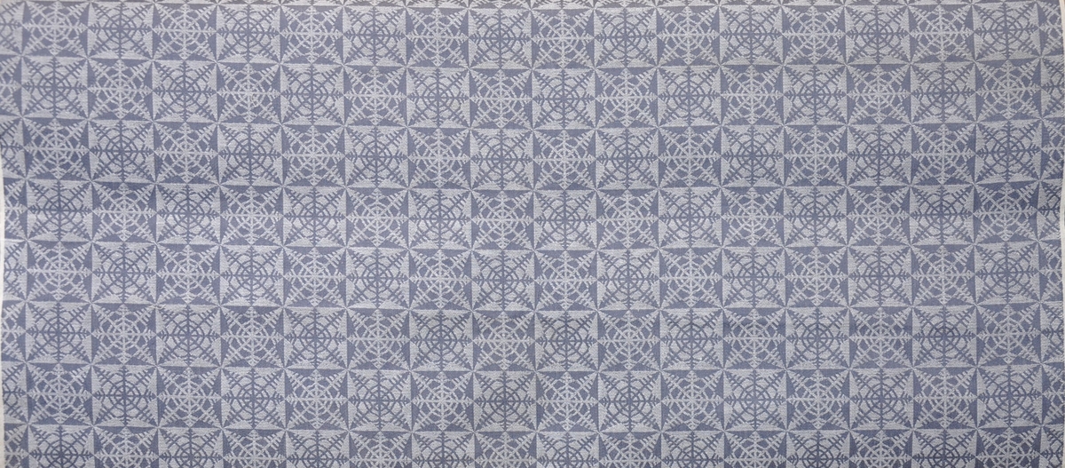 Bolstertyg, 1940-tal. 
Jacquardvävt tyg med blågrå varp, vitt inslag.
Bomull, 5-sk varp- och väftsatin.
Rapport 9,7 x 10,1 cm