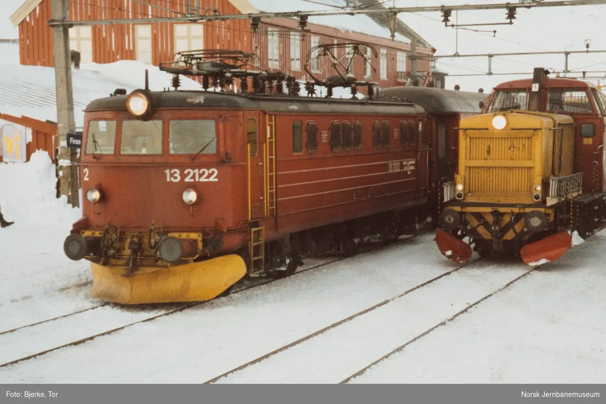 Elektrisk lokomotiv El 13 2122 med persontog retning Oslo på Finse stasjon. Til høyre diesellokomotiv Di 2 810, som var stasjonert på Finse stasjon