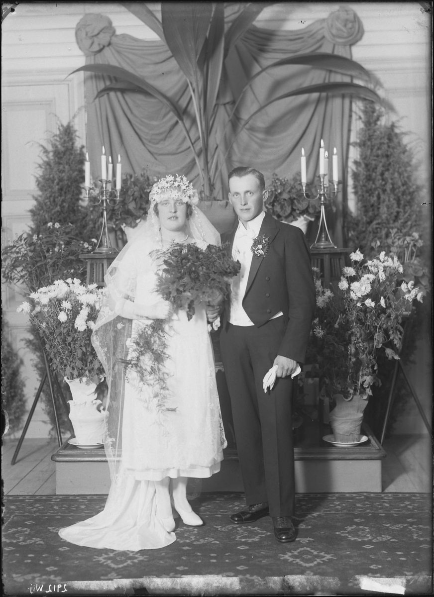 Fotografering beställd av Algot Johansson. Föreställer brudparet Erik Algot Johansson (1896-1968) och Hilma Elvira Vallén (1900-1987) som gifte sig den 25 oktober 1925, händelsevis på brudens födelsedag.