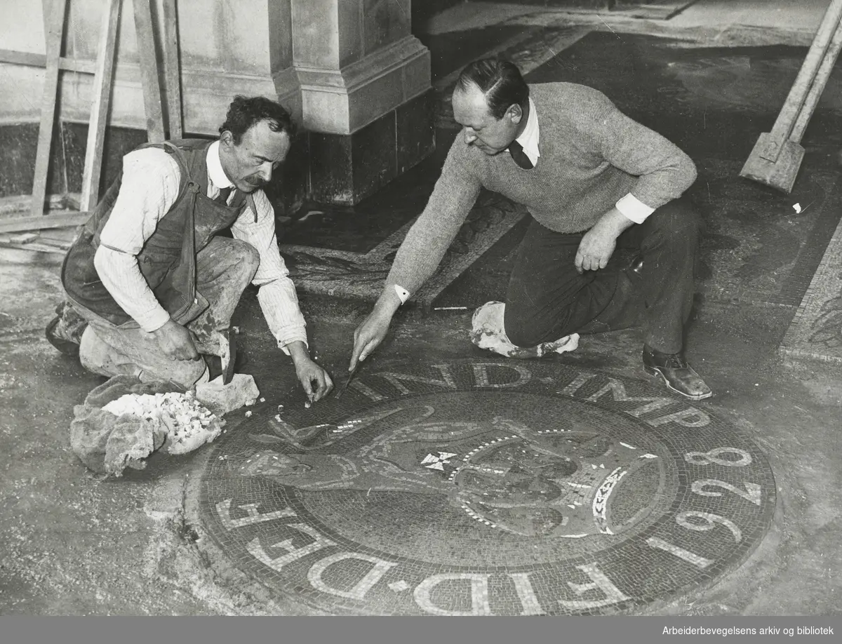 "En kunstner (Antatt Boris Anrep) og hans assistent legger ned et mosaikkmønster på gulvet i Bank of England, London. Mønstrene er tatt fra de forskjellige myntene." Antatt 1928. Arbeidermagasinet/Magasinet for Alle