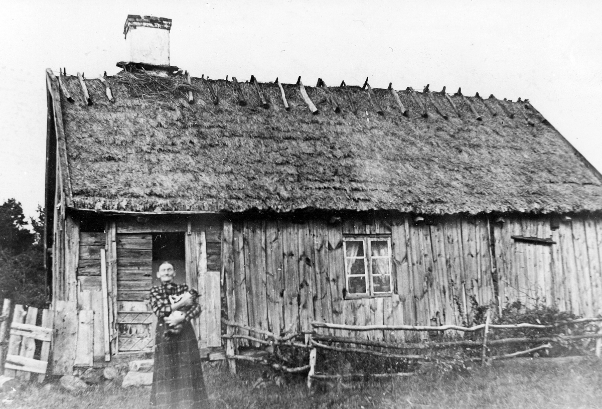 Johanna Augusta Bengtsson född 26/11 1856 i Kolebo, Slättåkra församling. Hon står utanför sitt torp, som kallades Gökatorpet och låg på ofri grund vid Kullarna under Susegården i Kvibille socken, foto från omkring 1910. Torpet revs något år senare.
