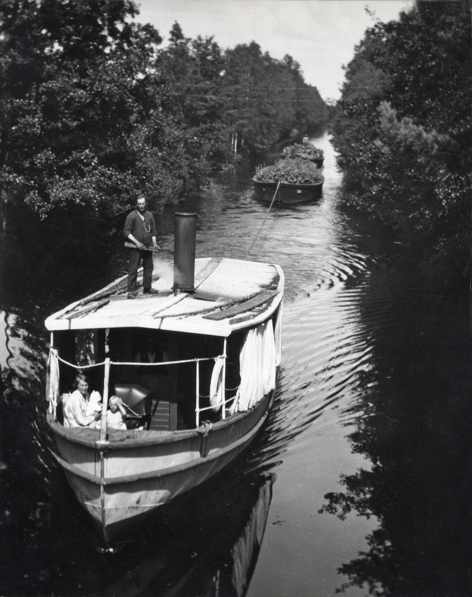 Ångbåten Thor i Asa kanal (?), 1930-tal. Man bogserar några pråmar med ved (?).