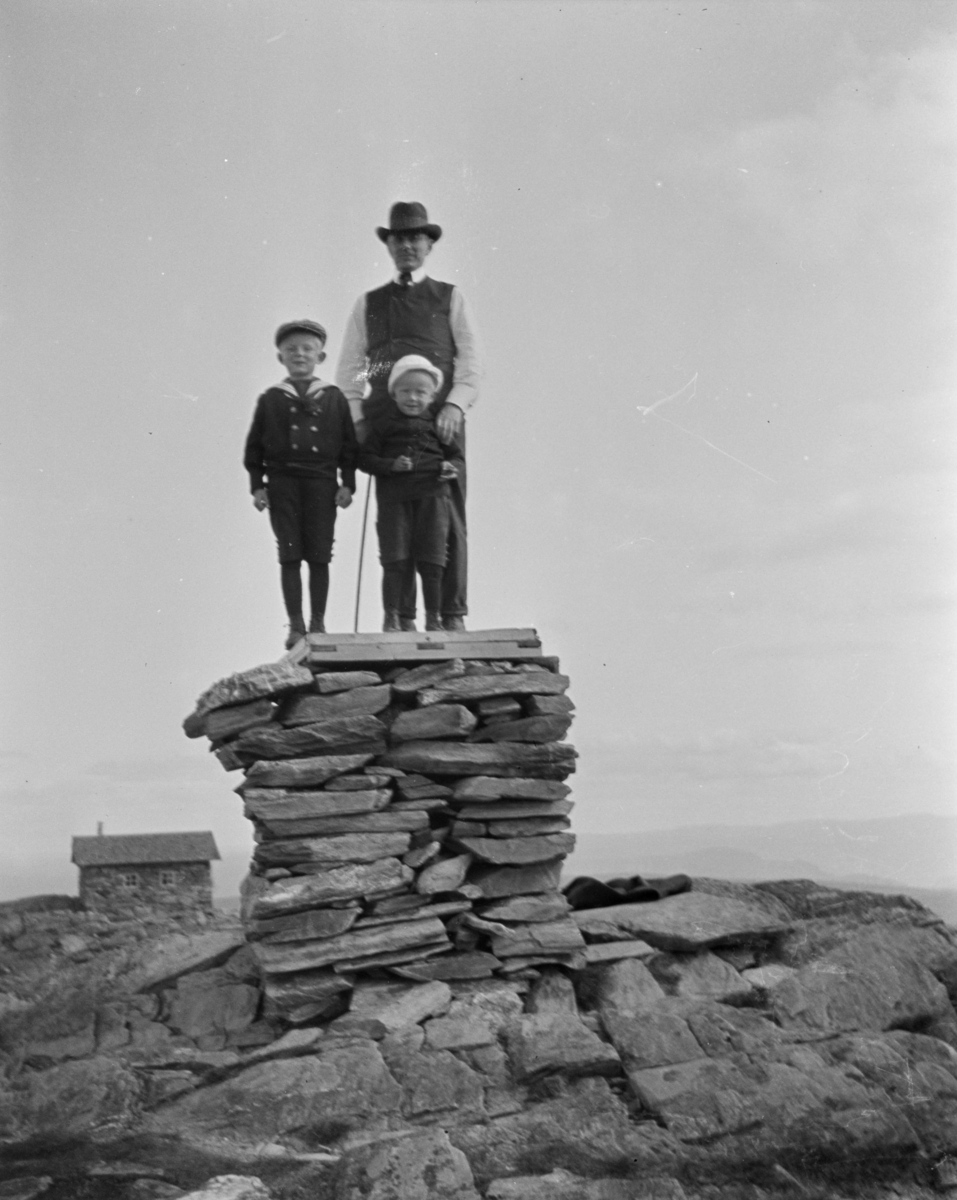 To gutter og en mann på toppen av varden på Skeikampen.