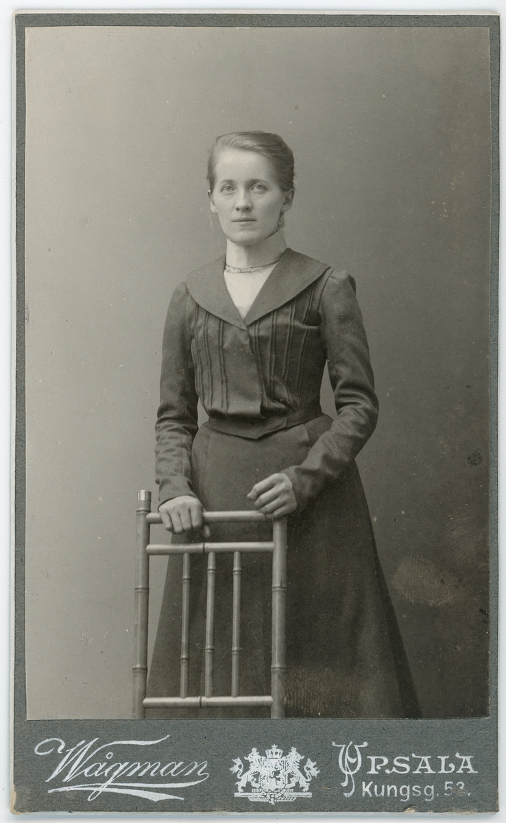 Kabinettsfotografi - kvinna står vid en stol, Uppsala