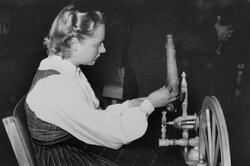 Mari Forberg (f. 1930 g. Åboen) ved rokken på ei handverksut