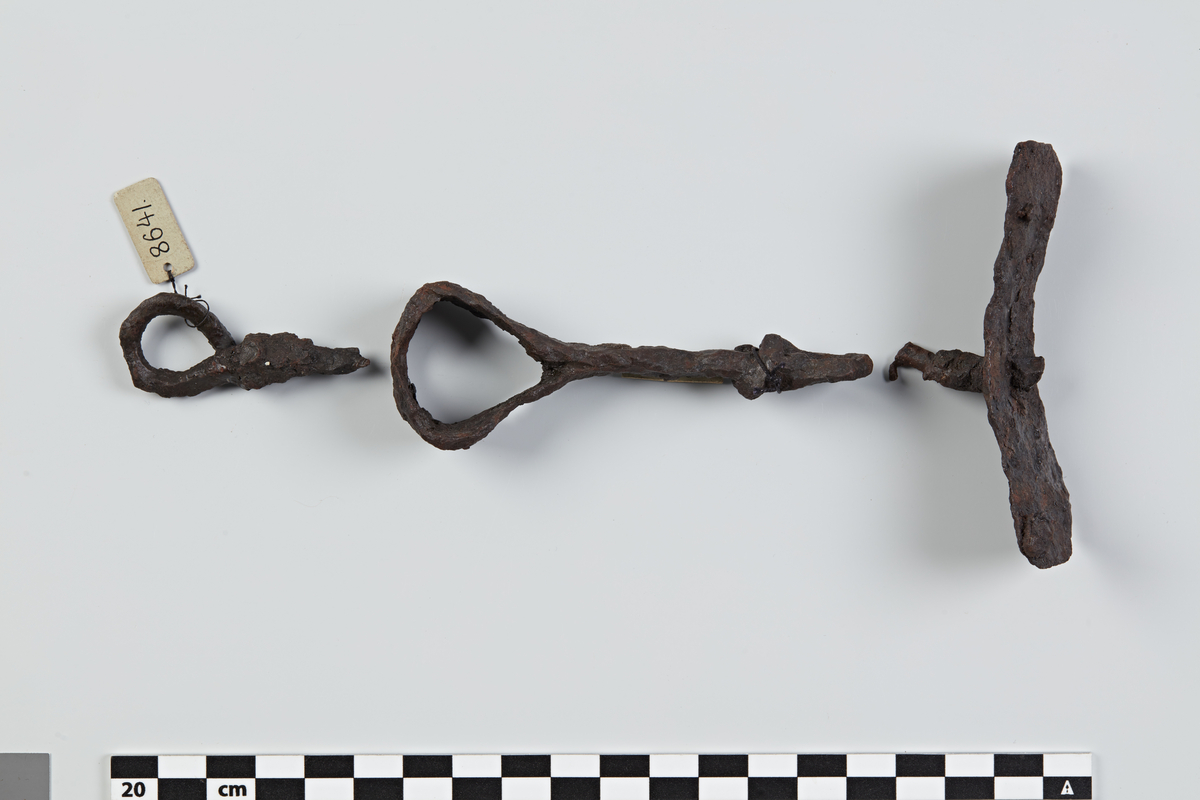 Nederstykket af en Hvirvel af Jern, af de mindre i sit Slags, 9.5 cm. langt. Deruden et Fragment (den øverste Del) af et ganske lignende Stykke. Kan maaske have hørt til Lænken No.8639.