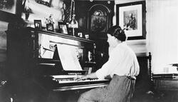 Gudrun Kopseng ved pianoet. På Øvre Kopseng, rundt 1916.