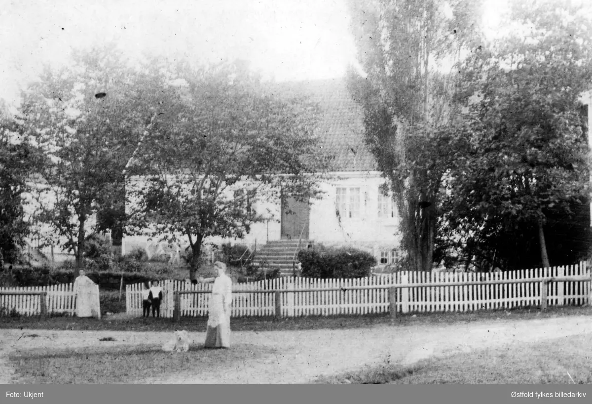 Skjeberg prestegård, to ukjente kvinner og to barn i forgrunnen. Uvisst hvilket år, muligens 1910-20?