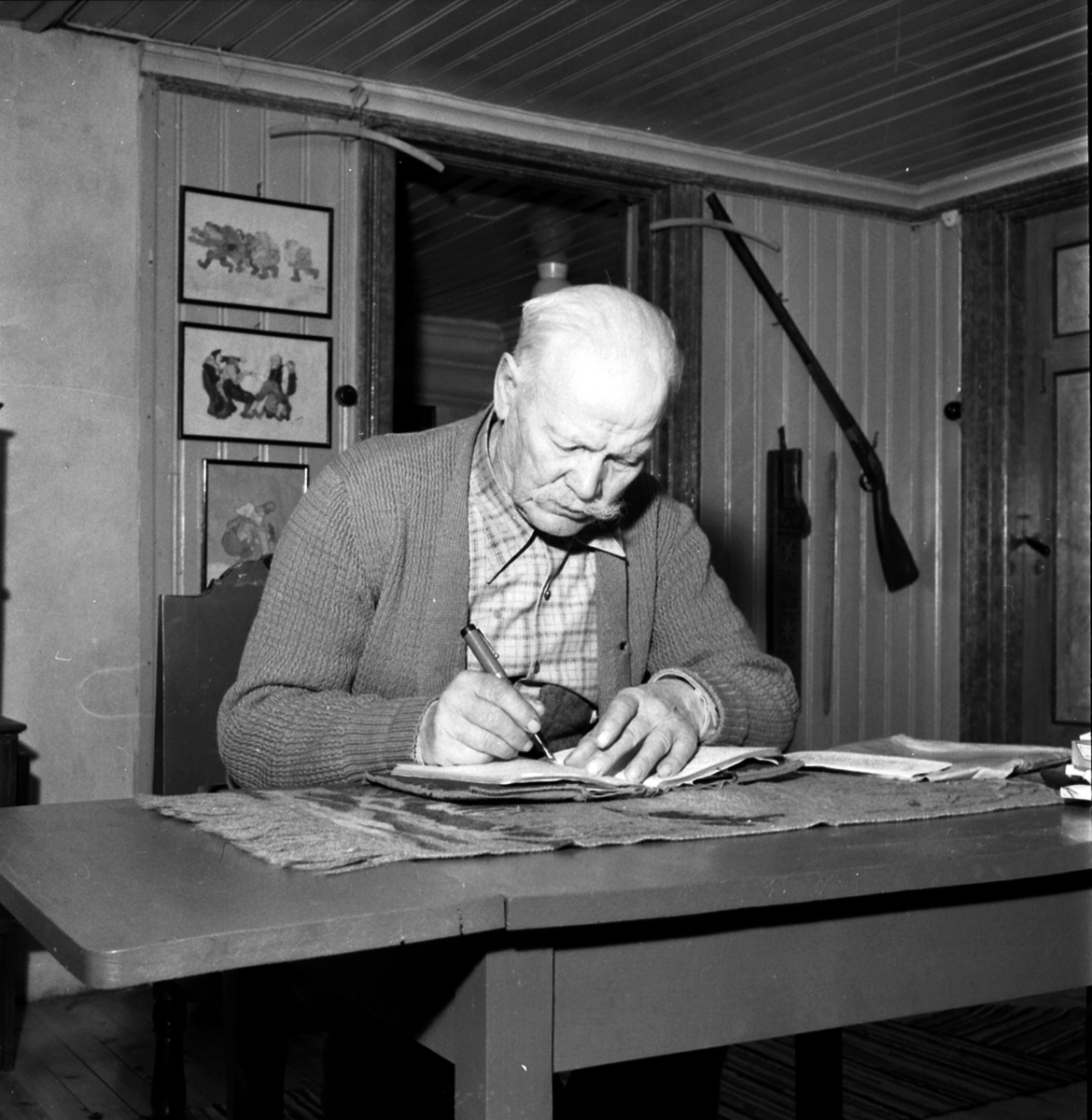 Nitahå-Jussi (til venstre) sitter ved bord og skriver, hjemme.
Nitahå-Jussi (født Johannes Johansson Oinonen 16. mai 1874 på Niitaho i Norra viggen, Värmland, død 13. februar 1964 i Torsby) var en skogsfinsk vandrer.