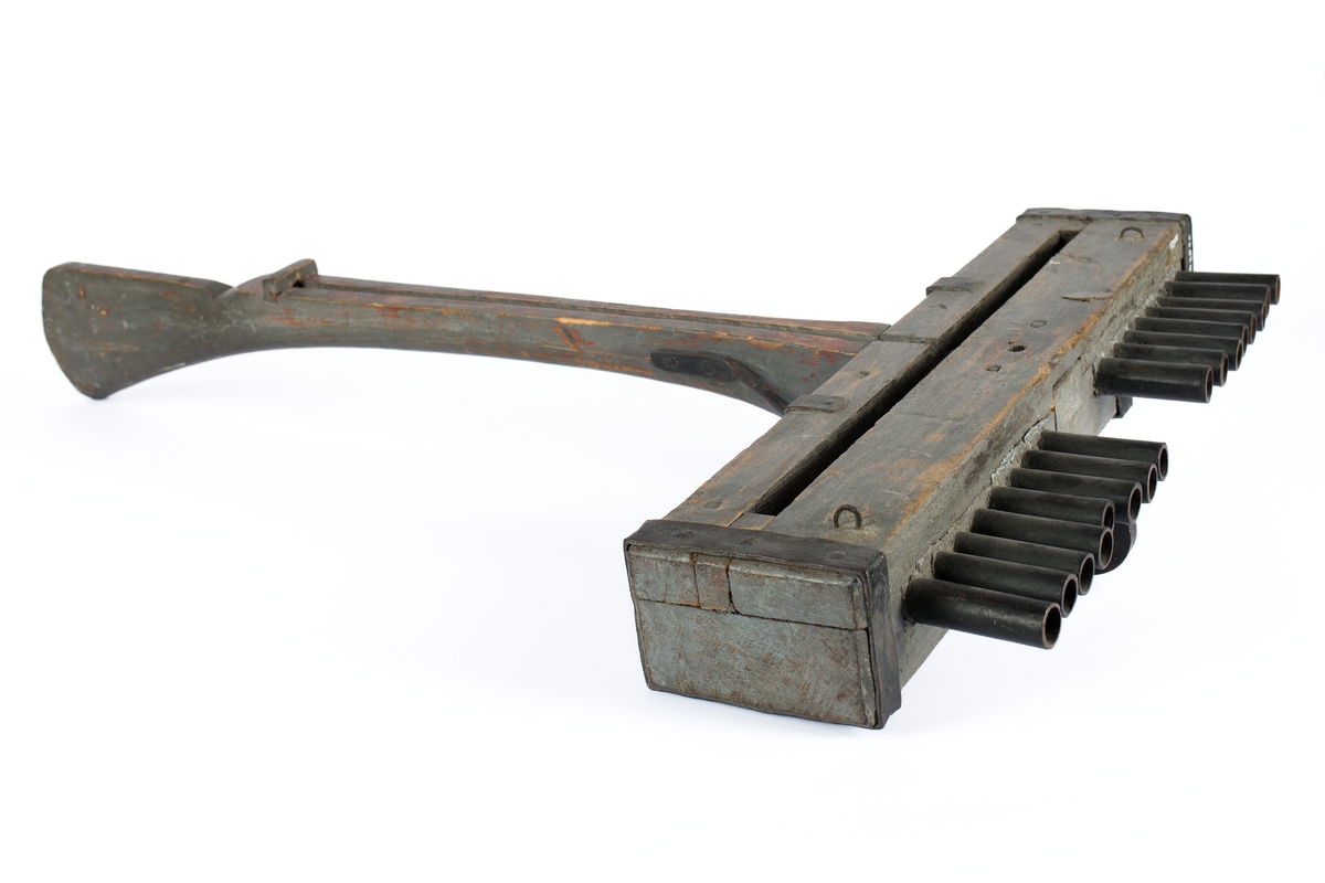 Skottbalk (orgelbössa).  Material: Trä med beslag av järn. Vapnet har 16 stycken pipor av järn. Från 1670-talet.