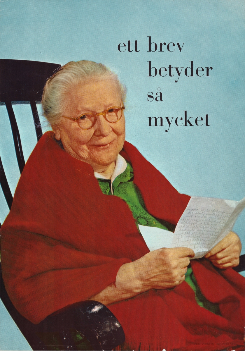 Äldre kvinna sitter i en gungstol omsvept av en röd filt. Kvinnan håller i ett handskrivet brev.